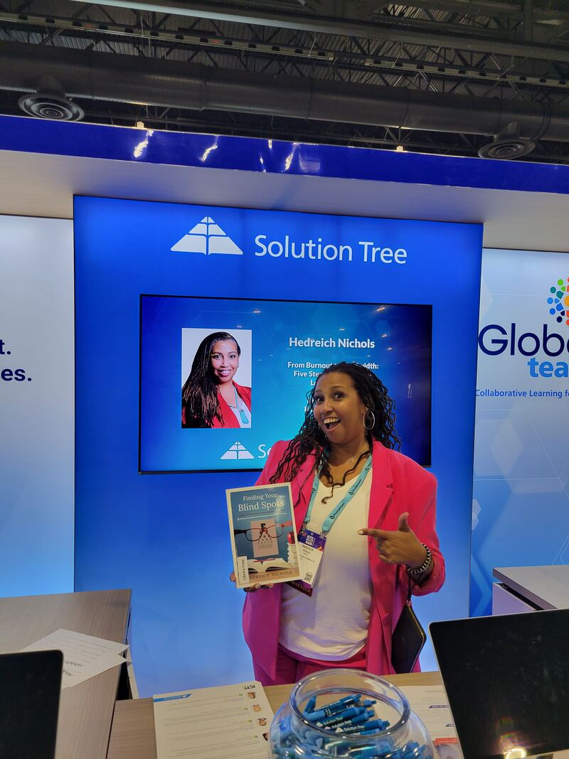 Hedreich at the Solution Tree booth holding her book