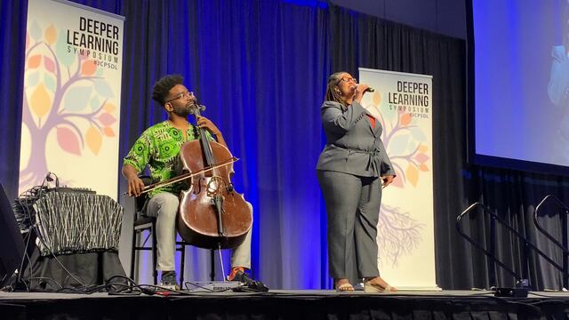 Hedreich on stage with a cellist at the Deeper Learning conference